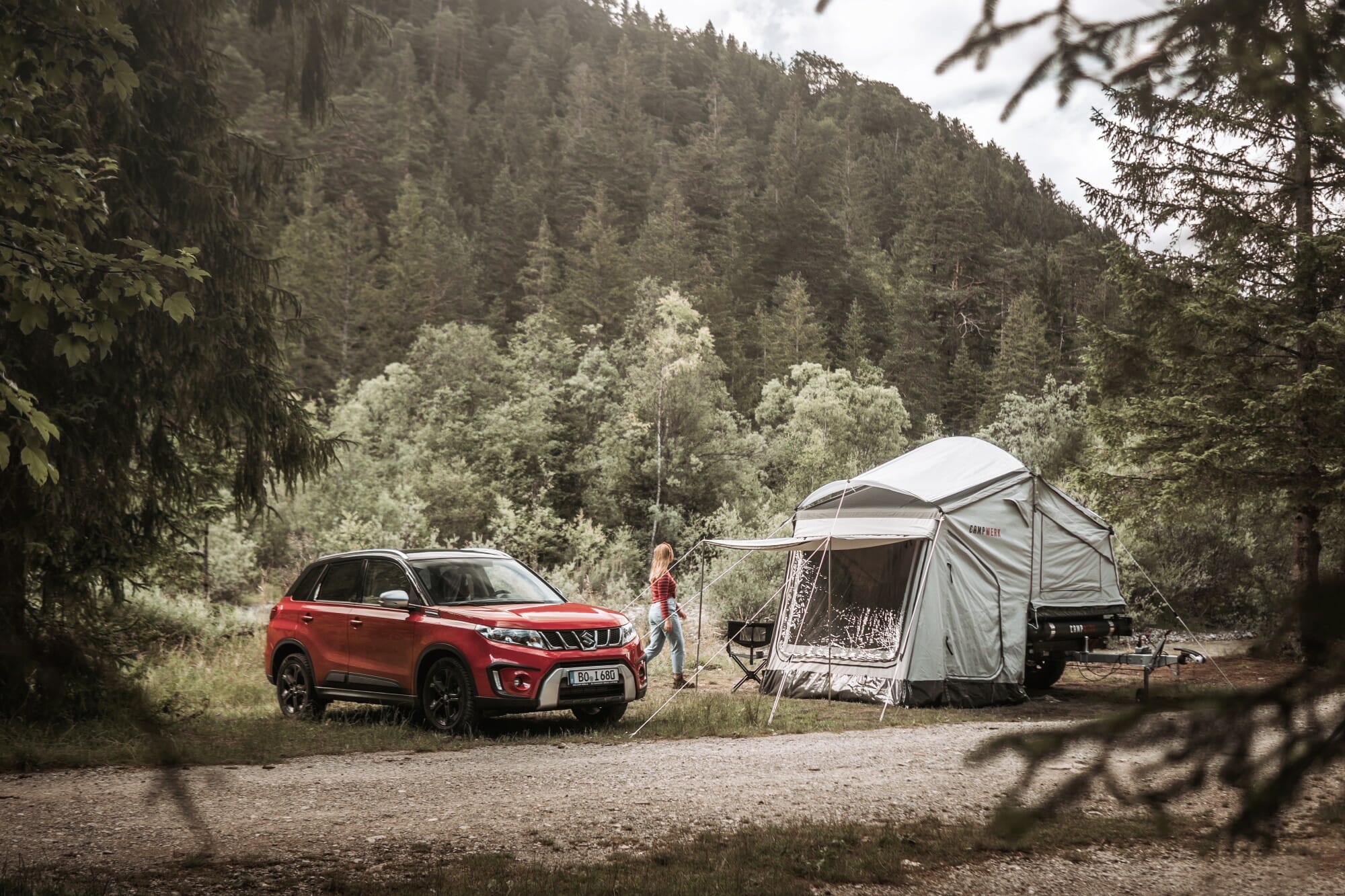 Roter SUV mit Dachzelt-Anhänger beim Camping in den Bergen – Natururlaub mit mobilem Schlafplatz