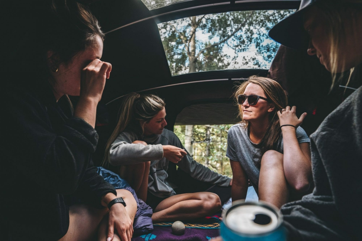 Freundinnen unterhalten sich in ihrem Dachzelt auf einem Campingplatz