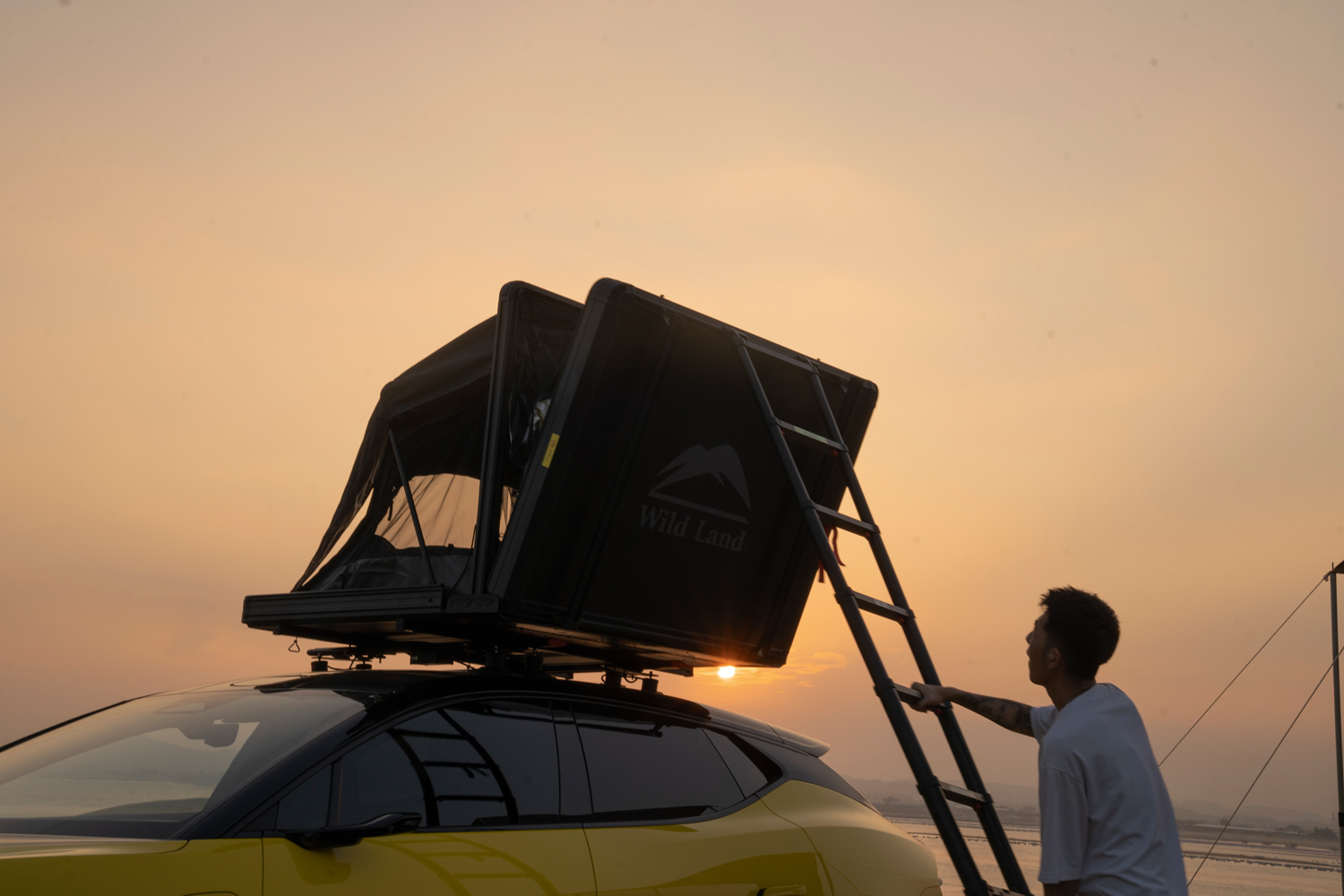 Camper klettert in sein Dachzelt