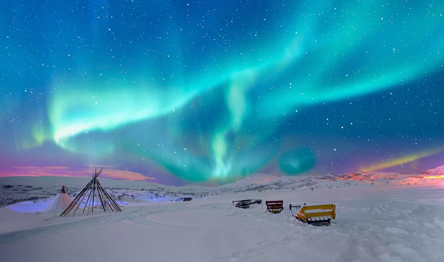Polarlichter über verschneiter Landschaft in Skandinavien als Highlight für Wintercamping